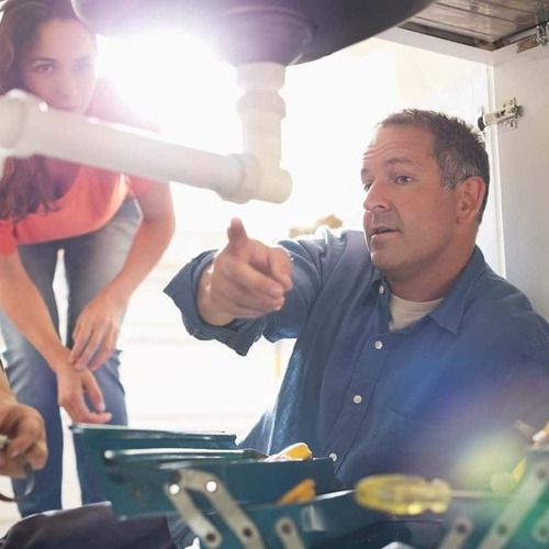 A Plumber Examines a Pipe.